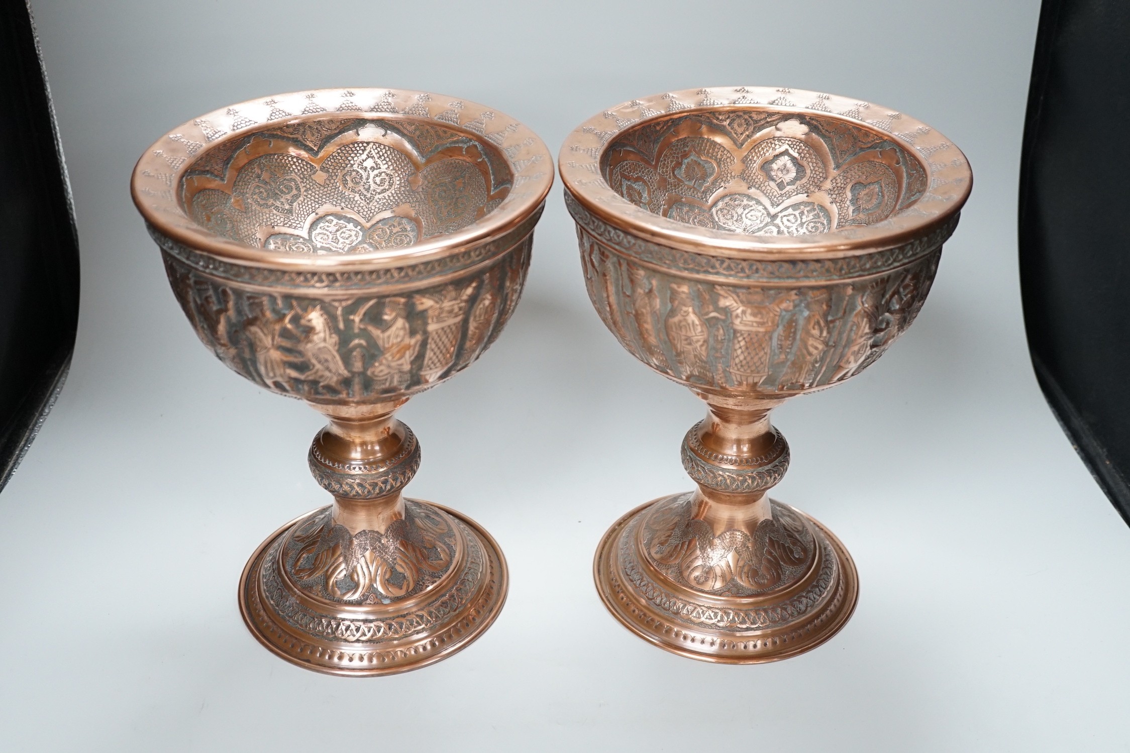 A pair of Persian copper figural decorated chalices, 27cms high